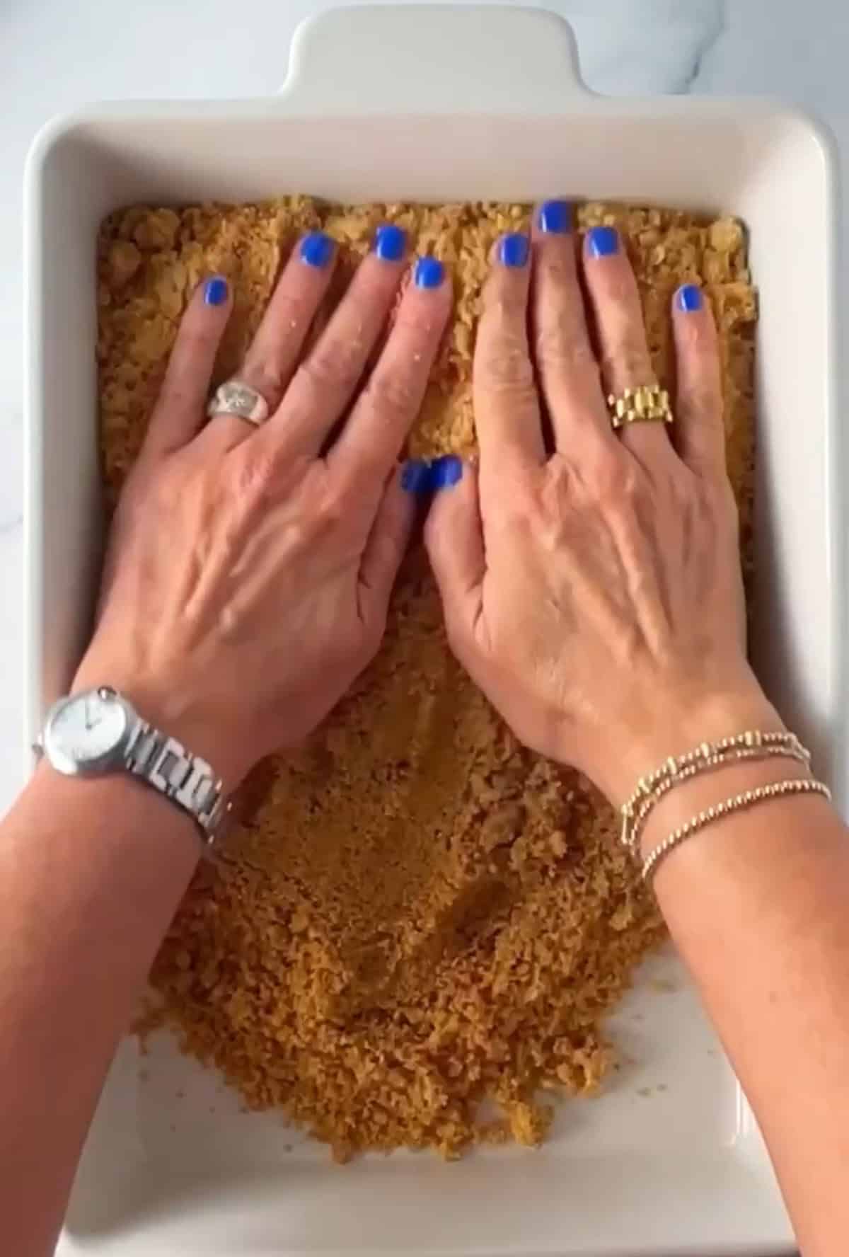 Making a graham cracker crust in a rectangular dish.