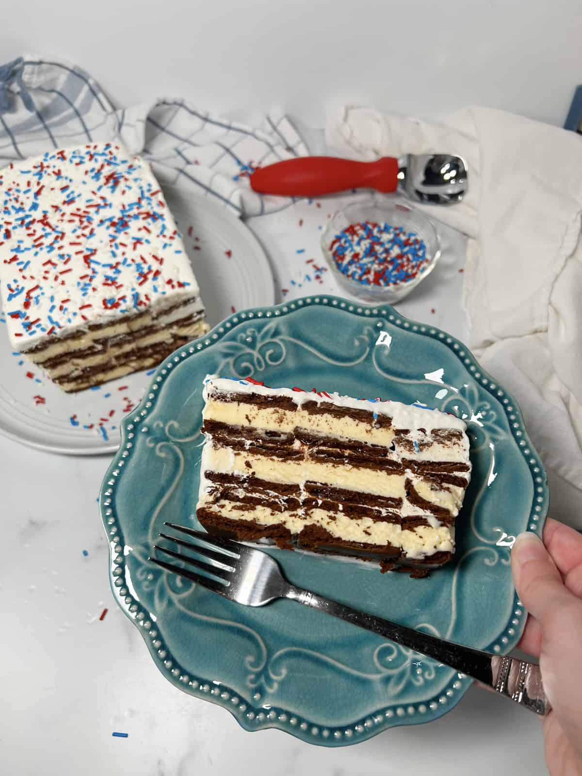 Slice of ice cream sandwich cake on a blue plate.