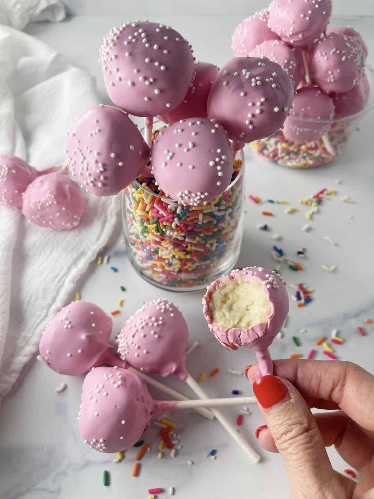 Homemade cake pops with pink candy coating.