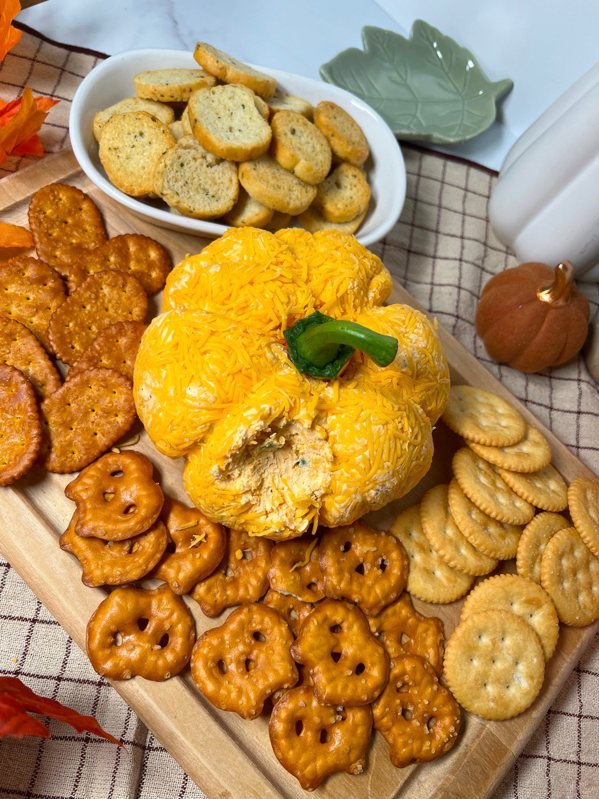 Appetizer tray with pumpkin shaped cheeseball and crackers.