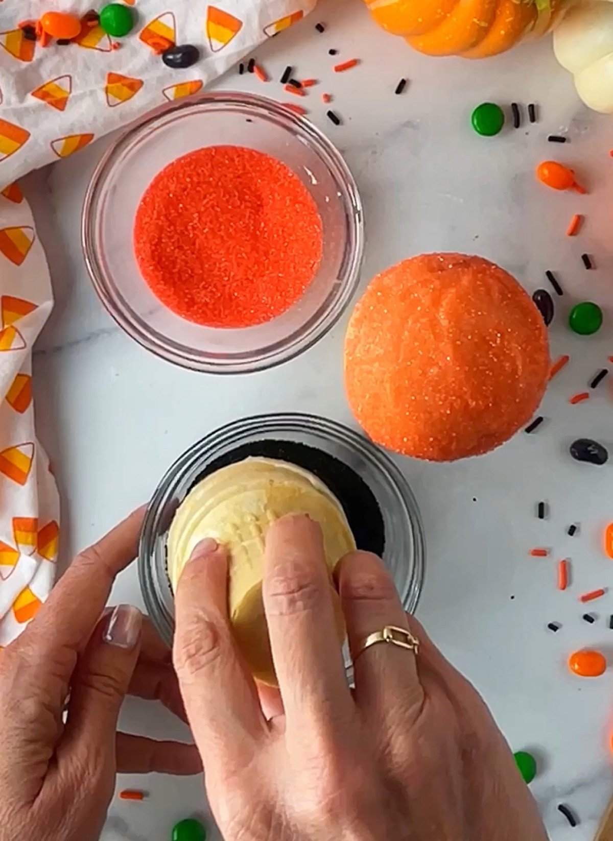 Dipping cupcake ice cream cone in black sprinkles.