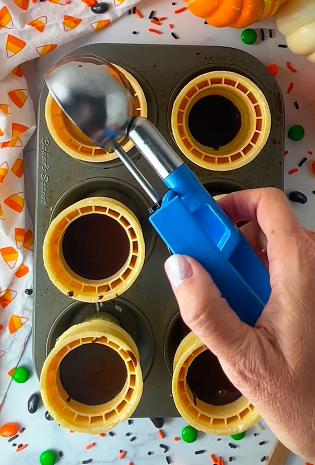 Cupcake batter in ice cream cones in a muffin pan.