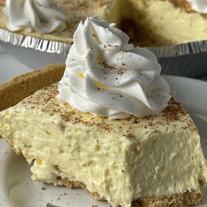 Slice of cream eggnog pie with whipped cream on top.