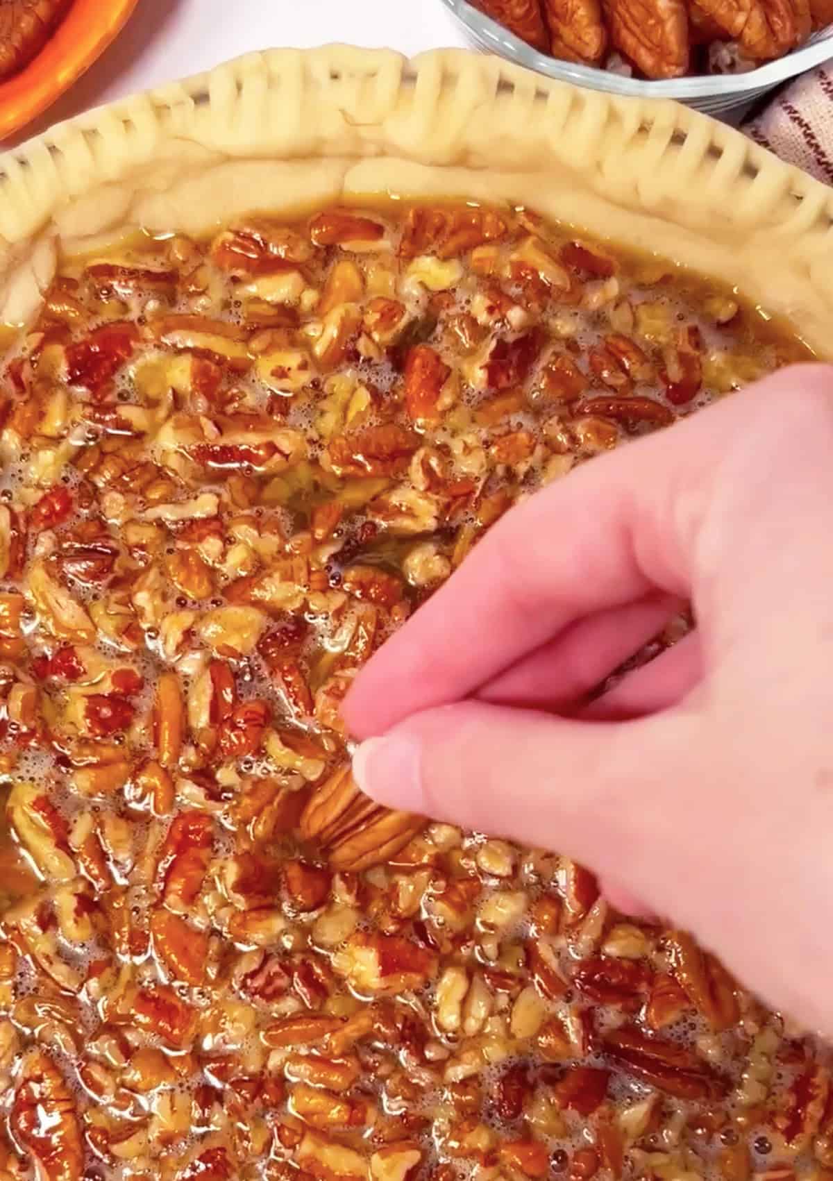 Placing pecans in a decorative pattern on top of pie.