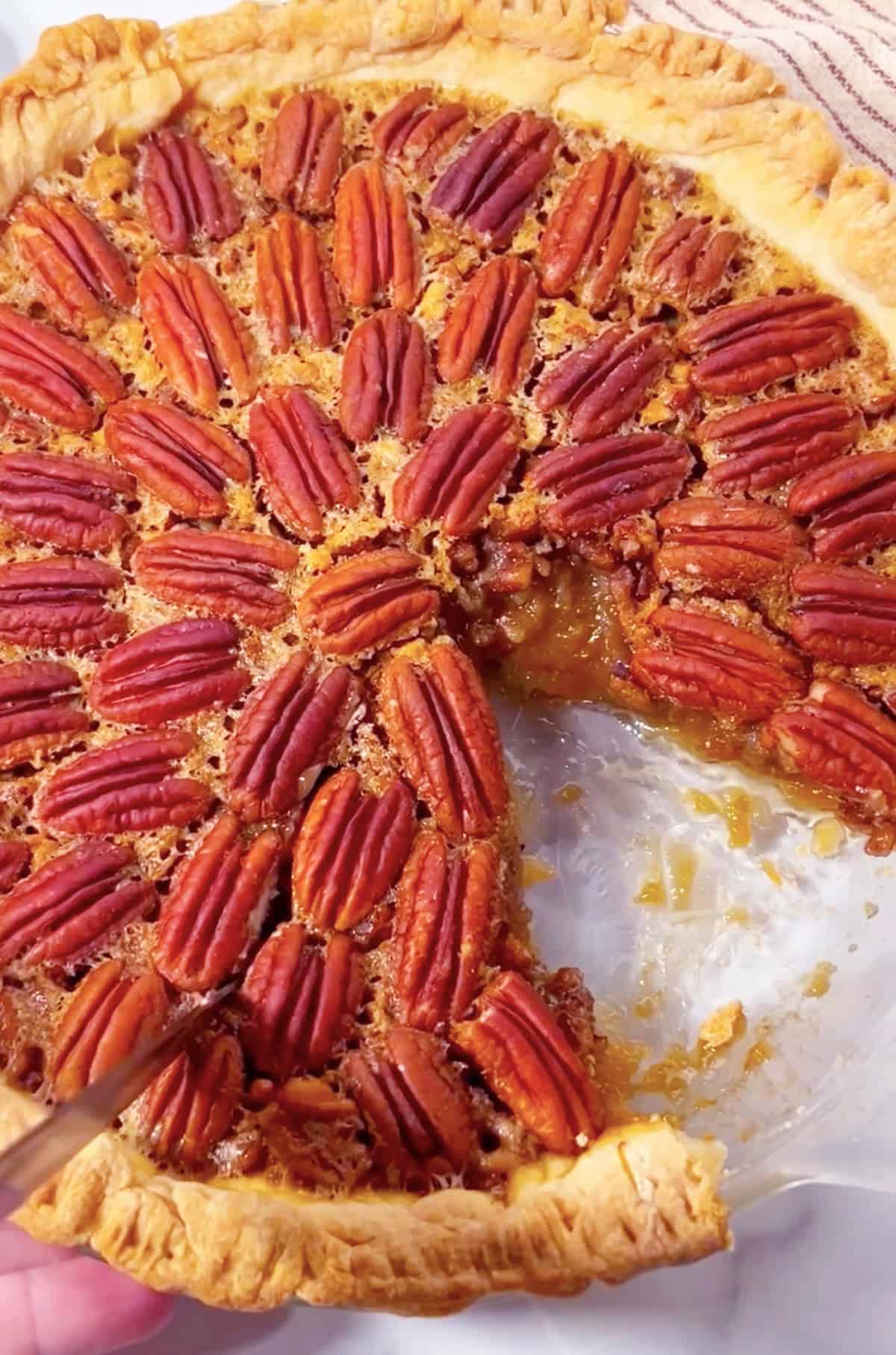 Homemade pecan pie with slice taken out.