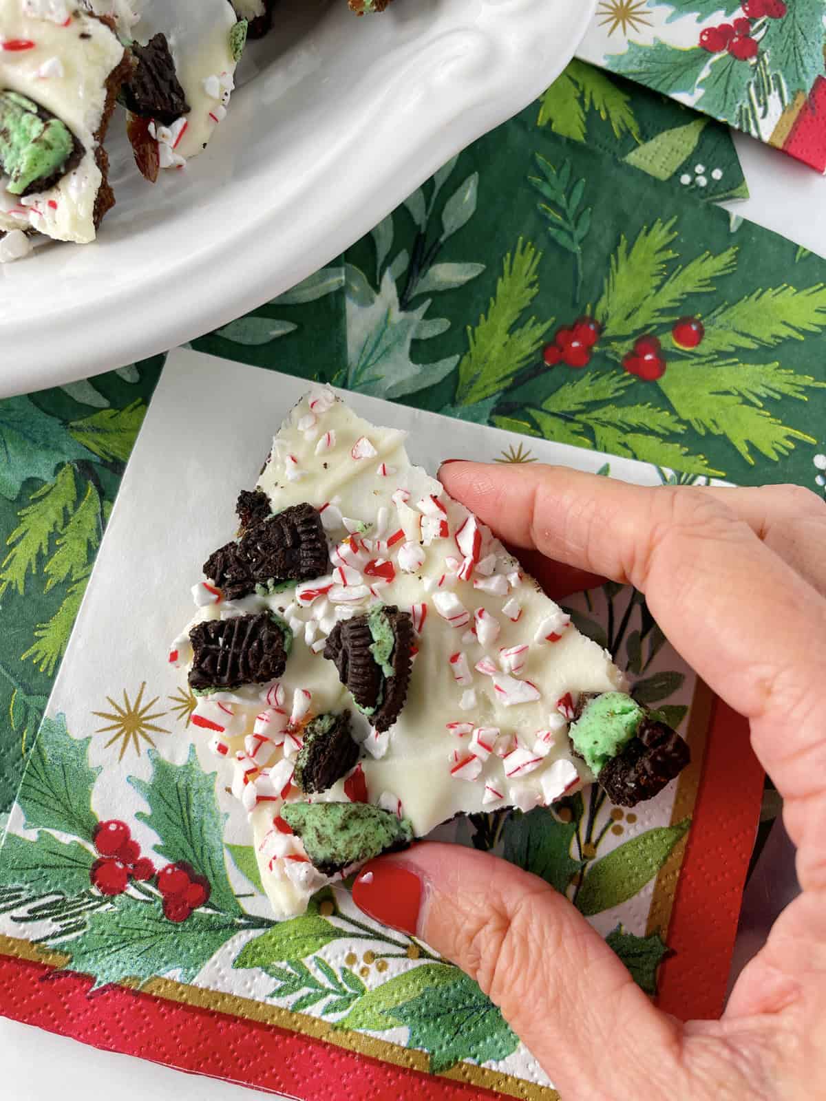 A piece of peppermint bark on a holiday napkin.