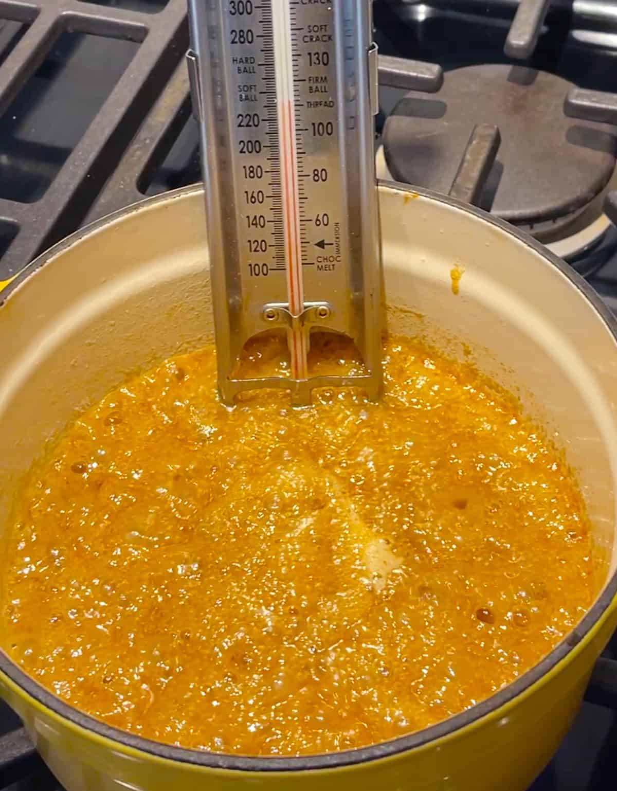 Boiling sugar and butter in a saucepan with candy thermometer.