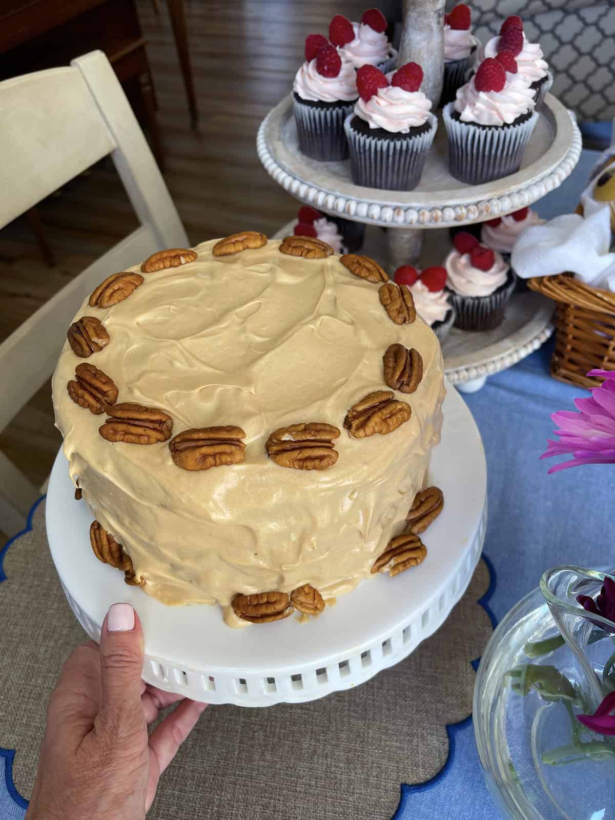 Caramel cake on white cake stand.