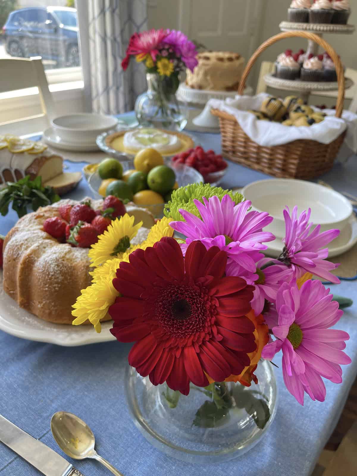 Pretty desserts and flowers on a table.